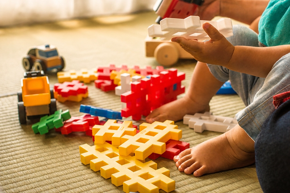 Kind spielt mit Bausteinen während der Kinderbetreuung