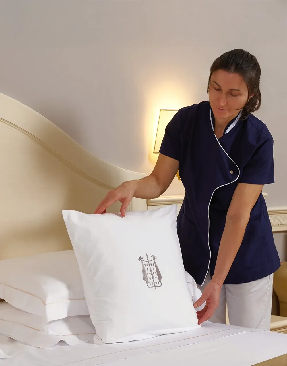 Governante che prepara il letto di una camera dell'hotel