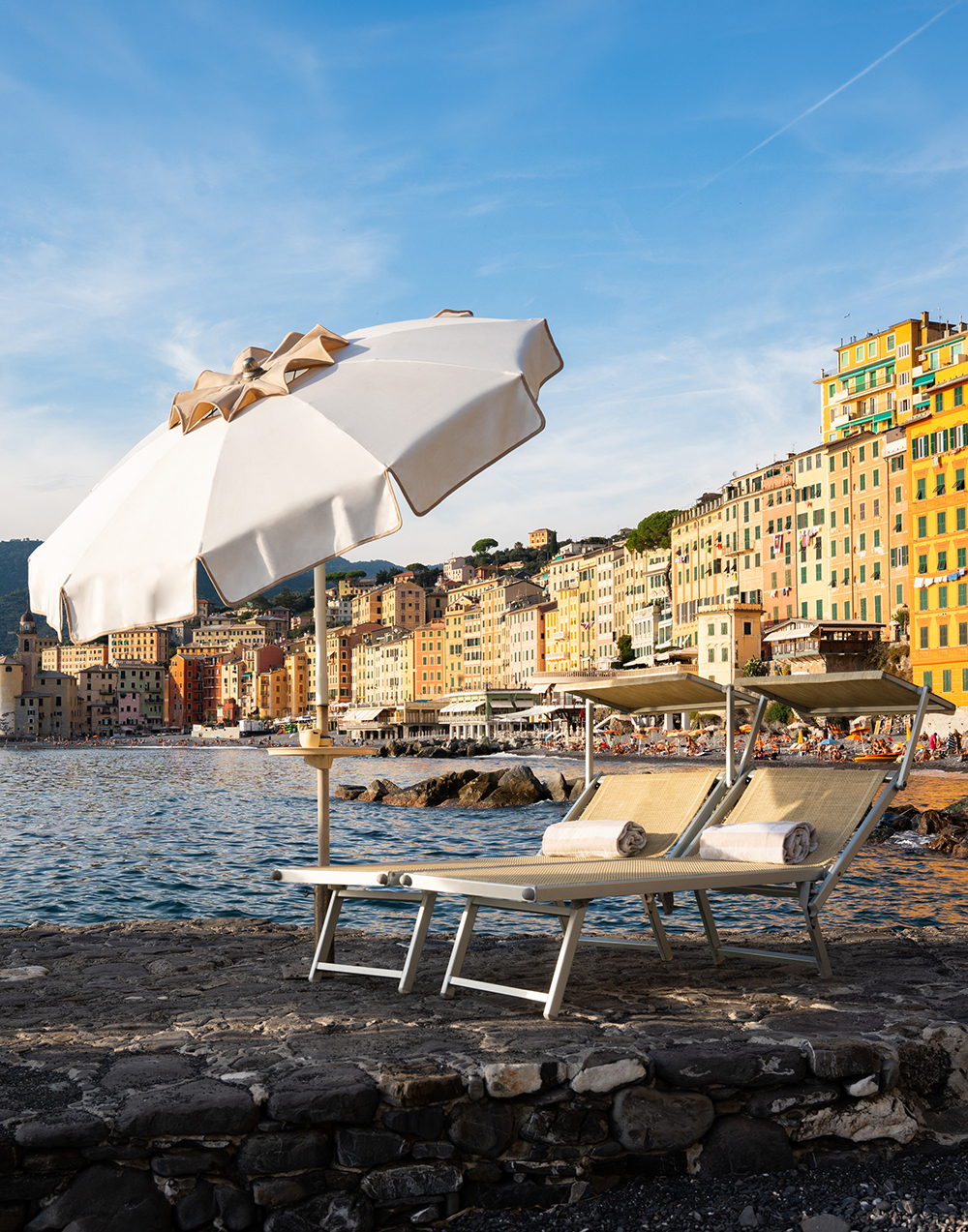 Liegen und Sonnenschirm am Hotelstrand vor dem Ort Camogli